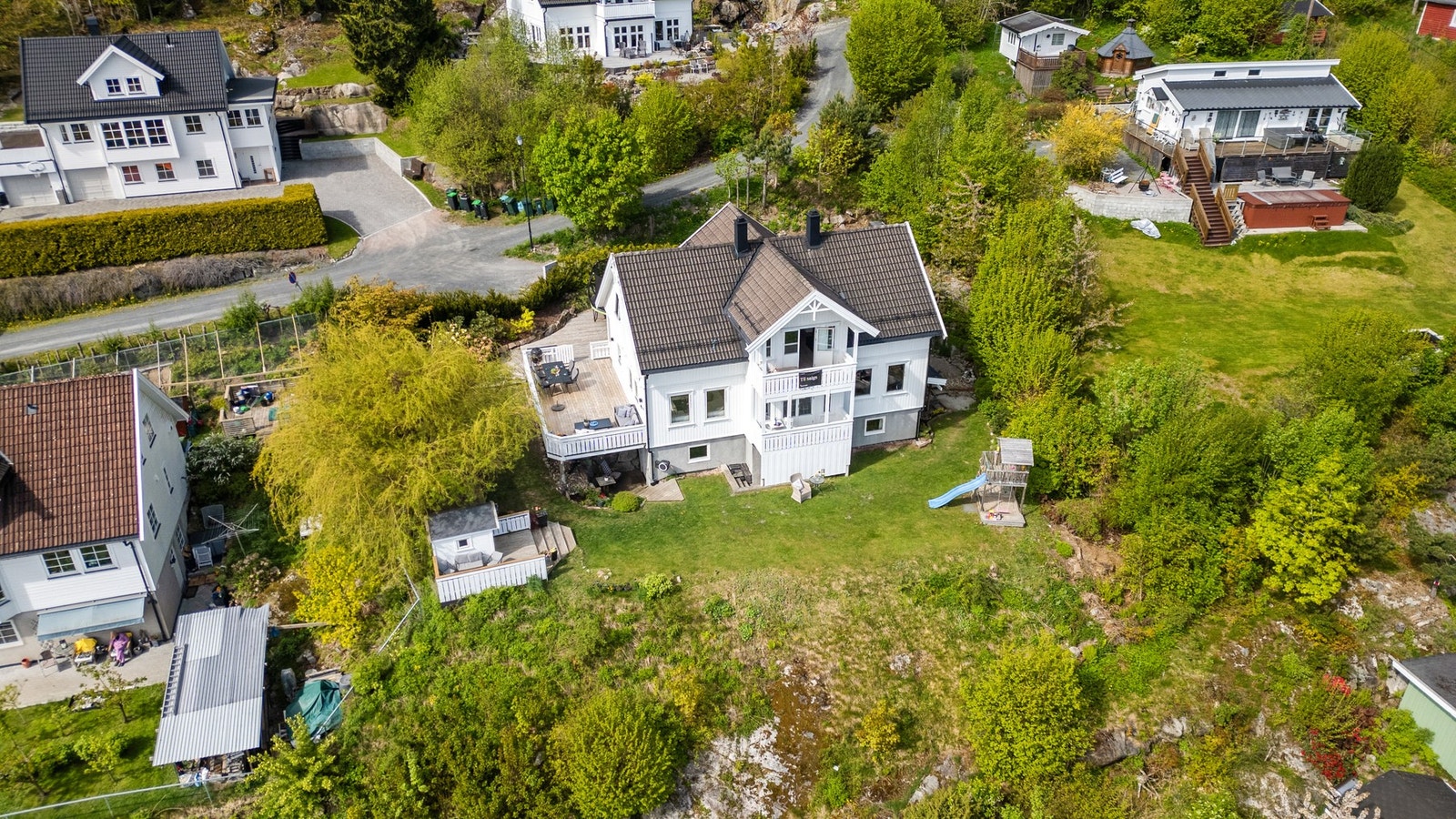 Tomten på 1007 kvm er pent opparbeidet med gressplen, gruslagt gårdsplass, trær og prydbusker. Galleribilde