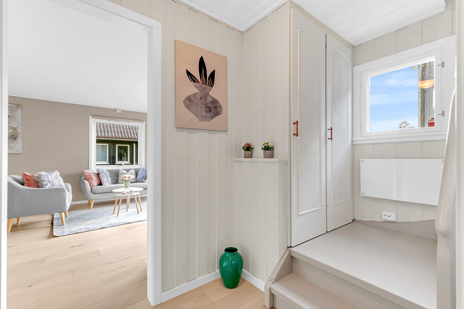 Trappegang med garderobe og nymalt panel. Stort vindu i trappen. Galleribilde