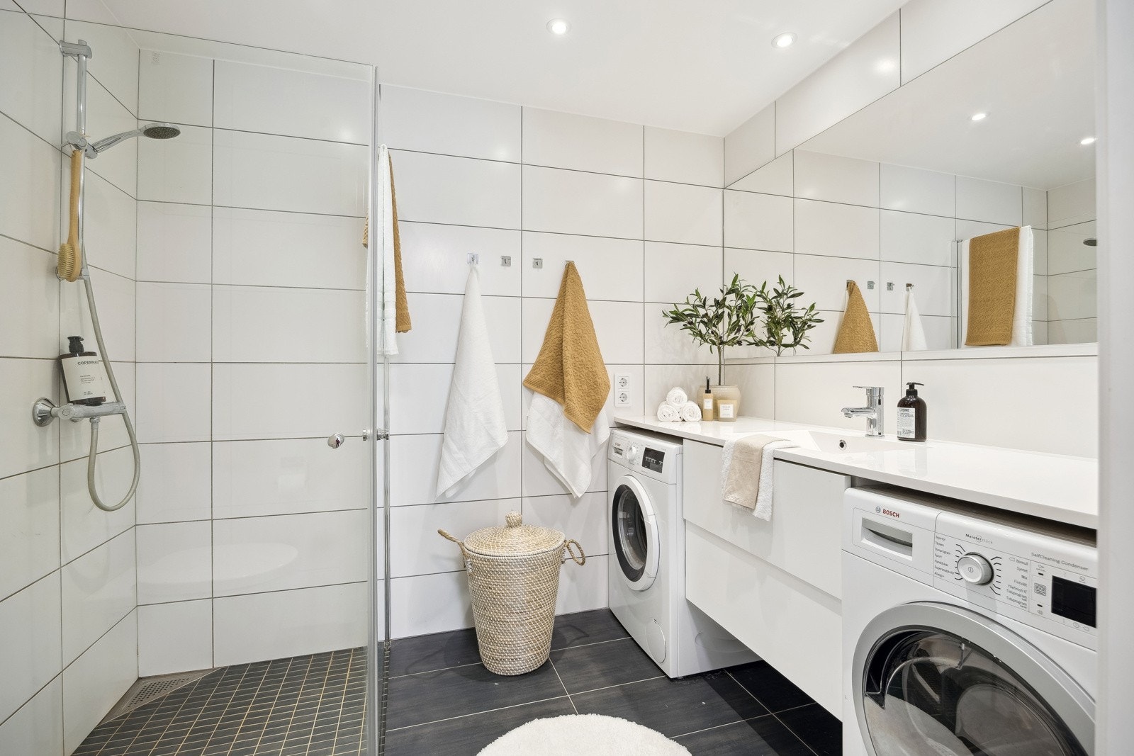 Flott flislagt bad på 5 m² med gulvvarme. Det er plass til både vaskemaskin og tørketrommel - en på hver side av innredningen. Galleribilde