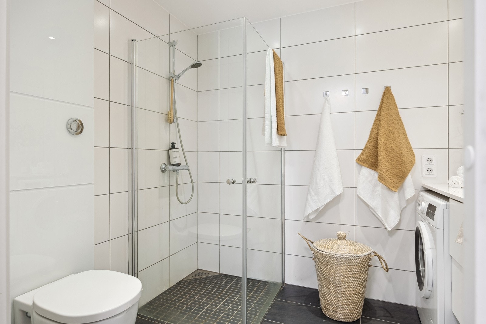 Baderommet består av dusjsone, vegghengt toalett og servant med underskap og speil. Galleribilde