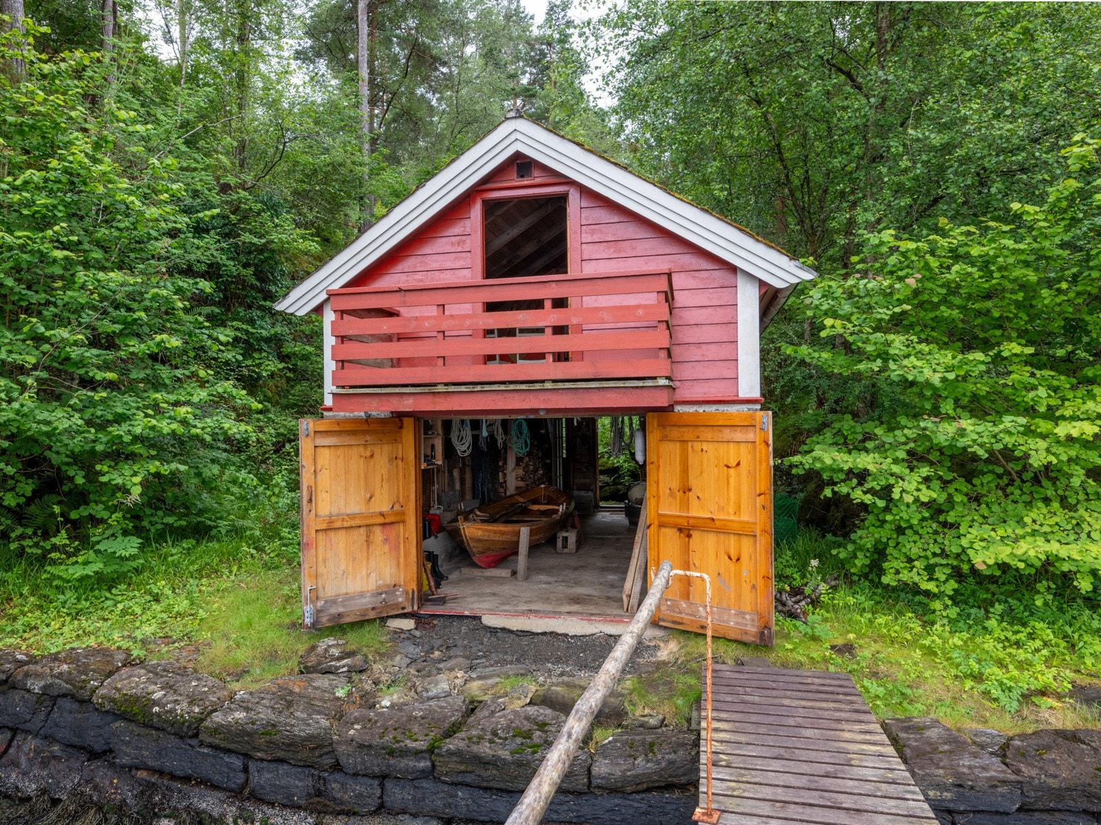 Nede er det god plass til småbåter og annet utstyr. Oppe er det spise- og soveplass. Galleribilde