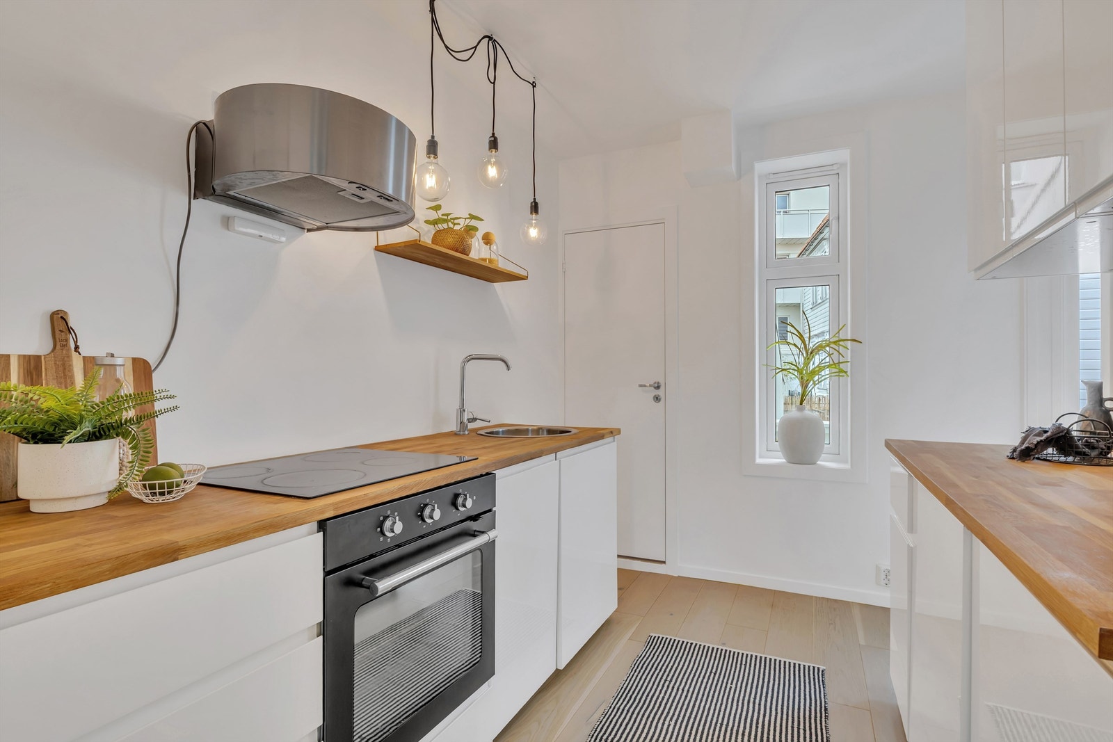 Pen kjøkkeninnredning fra 2018 med glatte fronter og benkeplate av tre. Galleribilde