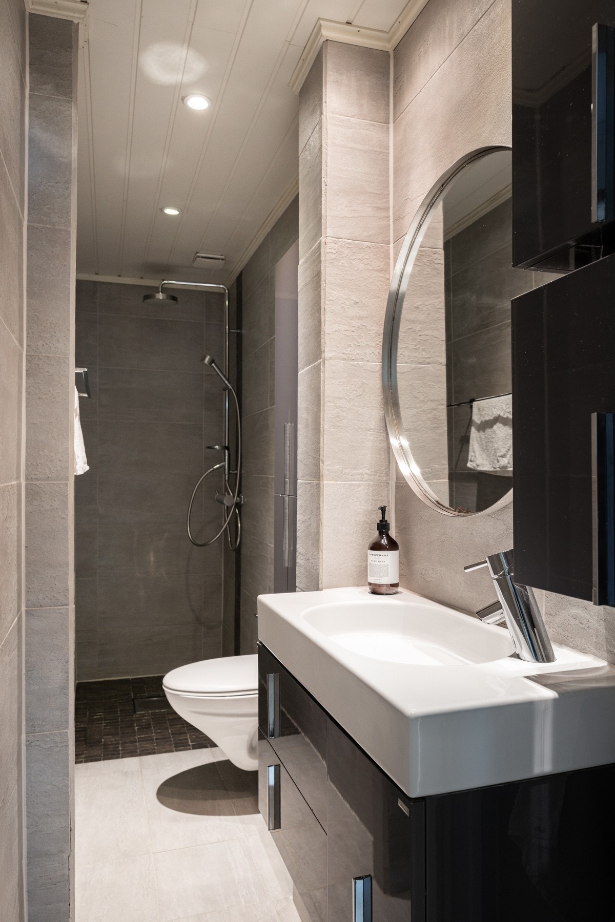 Bad/WC. Flislagt gulv med varmekabler, flislagte vegger og malt panel i himling med downlights. Galleribilde