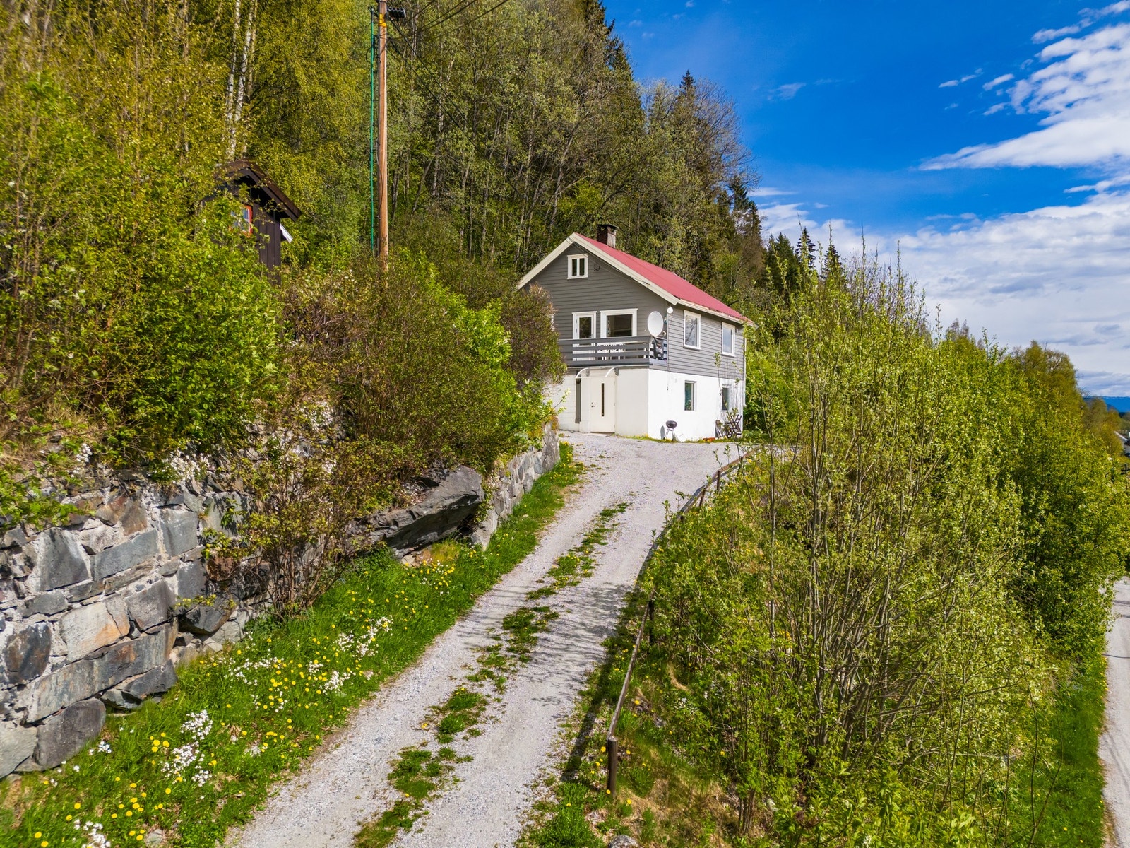 Tomten er noe opparbeidet med plen og noe beplantning. Galleribilde