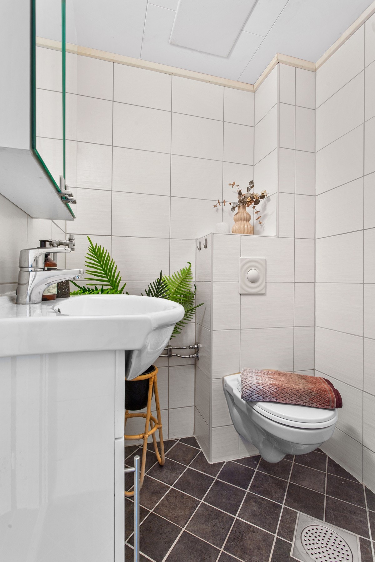 Varme i gulv og downlights i himling. Baderomsinnredningen har glatte, hvite fronter og består av en heldekkende servant på en skapseksjon, og et speilskap med hyller og belysning. Galleribilde