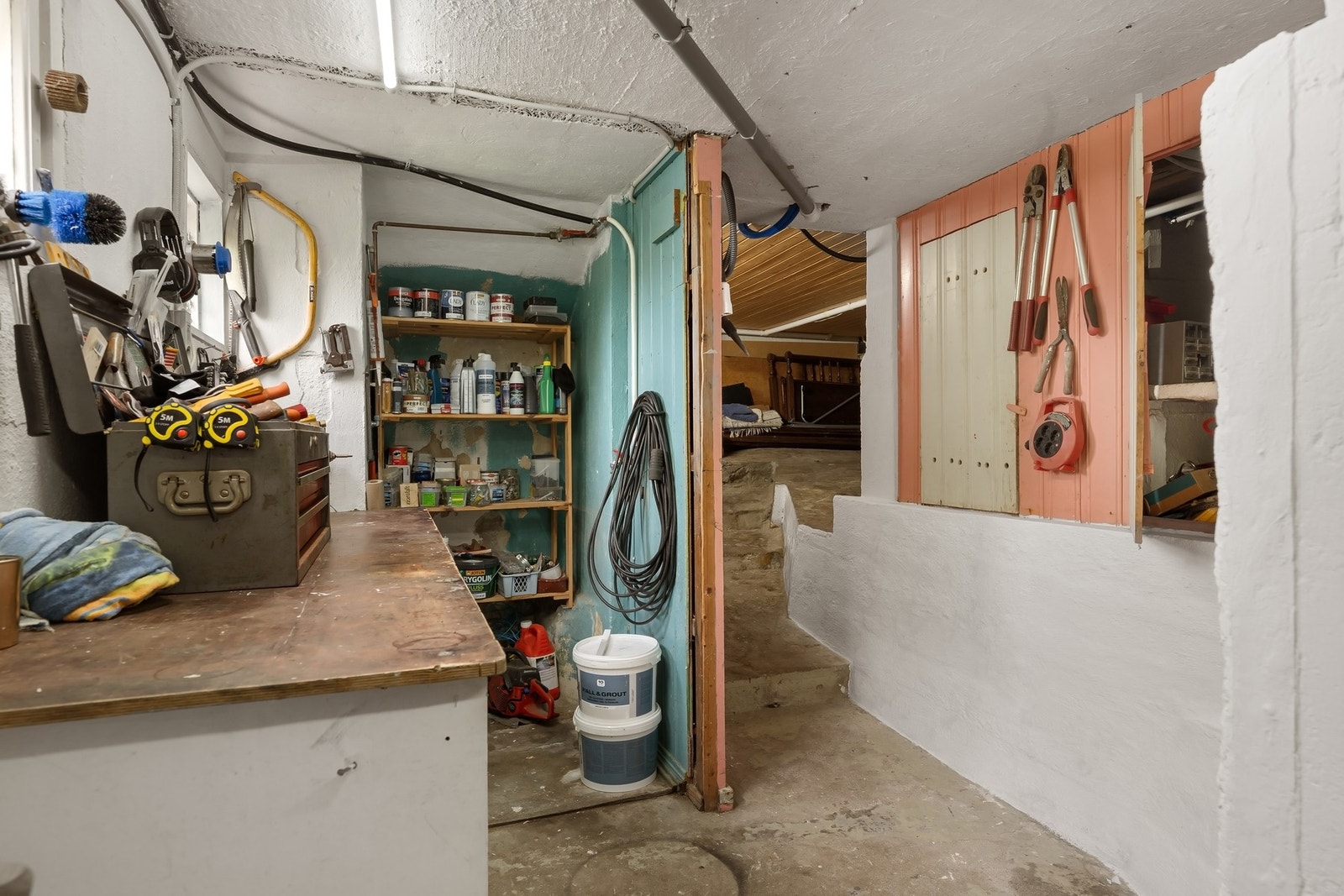 Krypkjeller med arbeidsbenk. Her er det plasser varmtvannsbereder, pumpe og trykktank for borevann, og tekniske fasiliteter m.m. Galleribilde