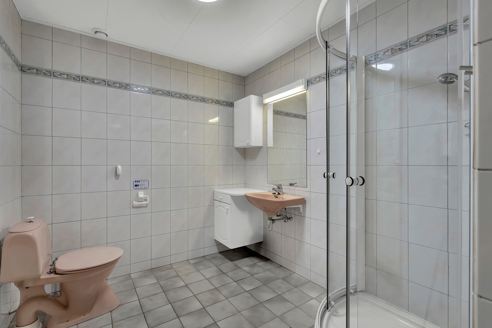 Badet i underetasjen har flislagte overflater og er utstyrt med dusjkabinett, toalett og servant. Galleribilde