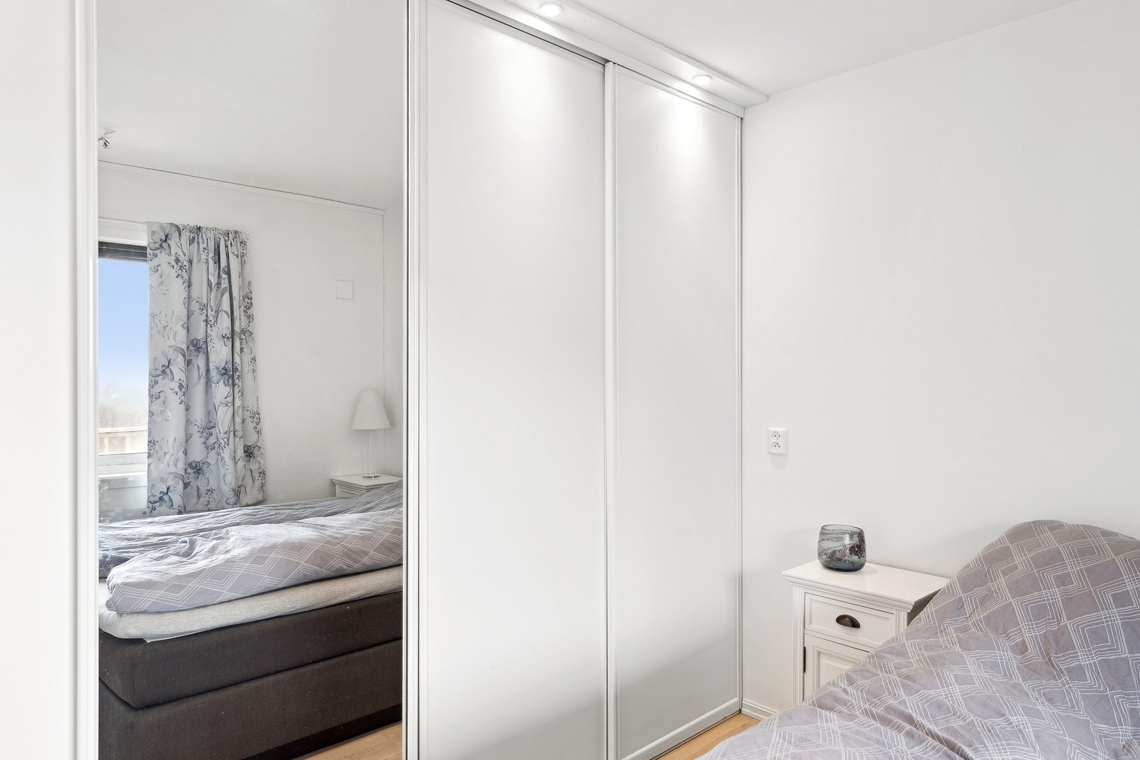 Innredet med skyvedørsgarderobe, dobbeltseng og nattbord. Galleribilde