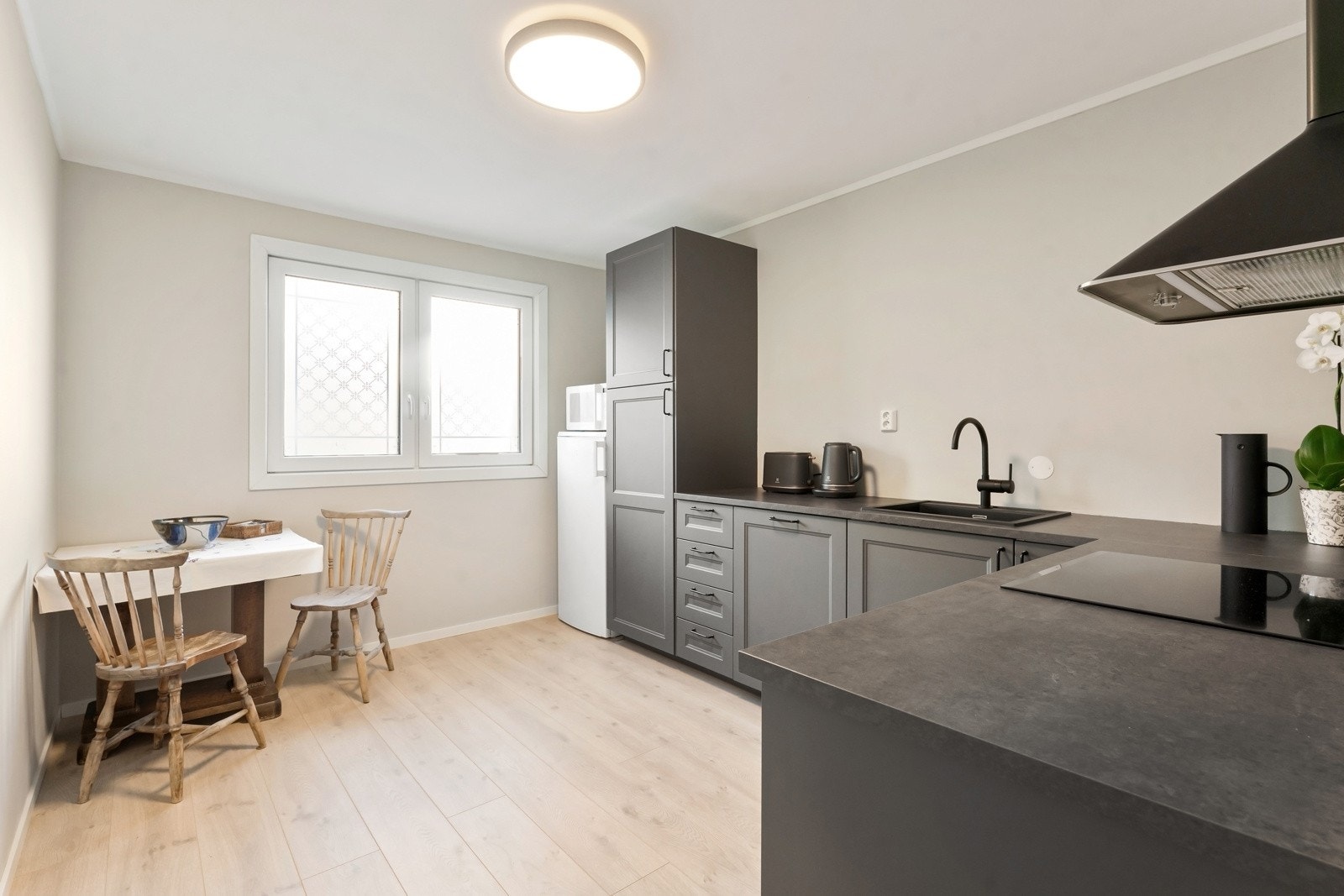 Lekkert og moderne kjøkken som består av mørke fronter og benkeplate i laminat. Galleribilde