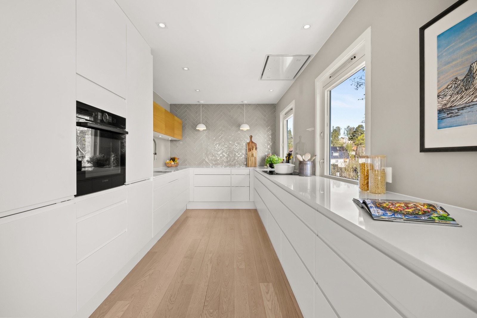 Pent og moderne kjøkken fra 2020 med hvit innredning og slette fronter som gir et rent og tidløst uttrykk. Galleribilde