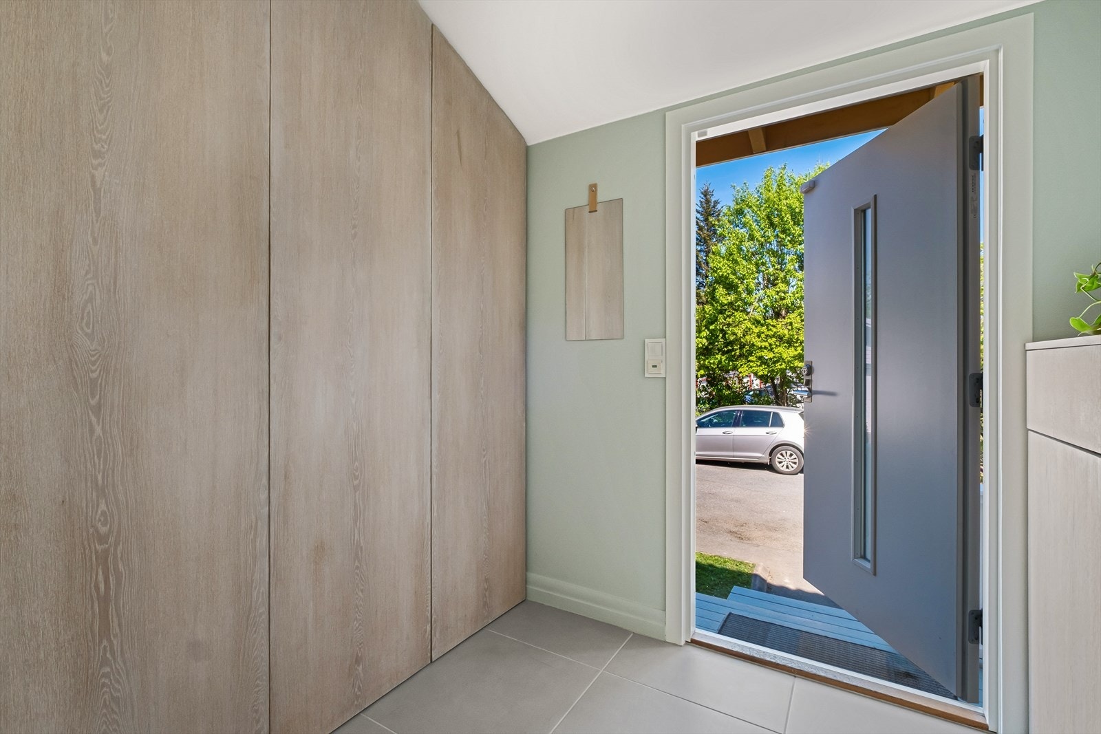 Romslig entré med garderobe, innebygd skoskap og flislagt gulv med varmekabler. Galleribilde