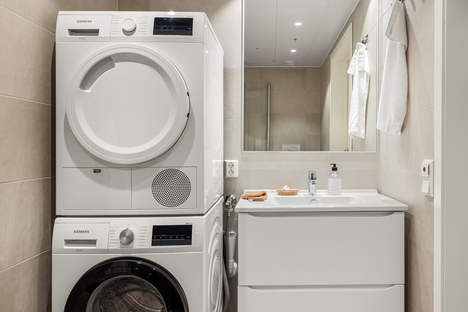Badet er innredet med baderomsmøbel, dusj m/glassdører, vegghengt toalett og opplegg for vaskemaskin. Galleribilde