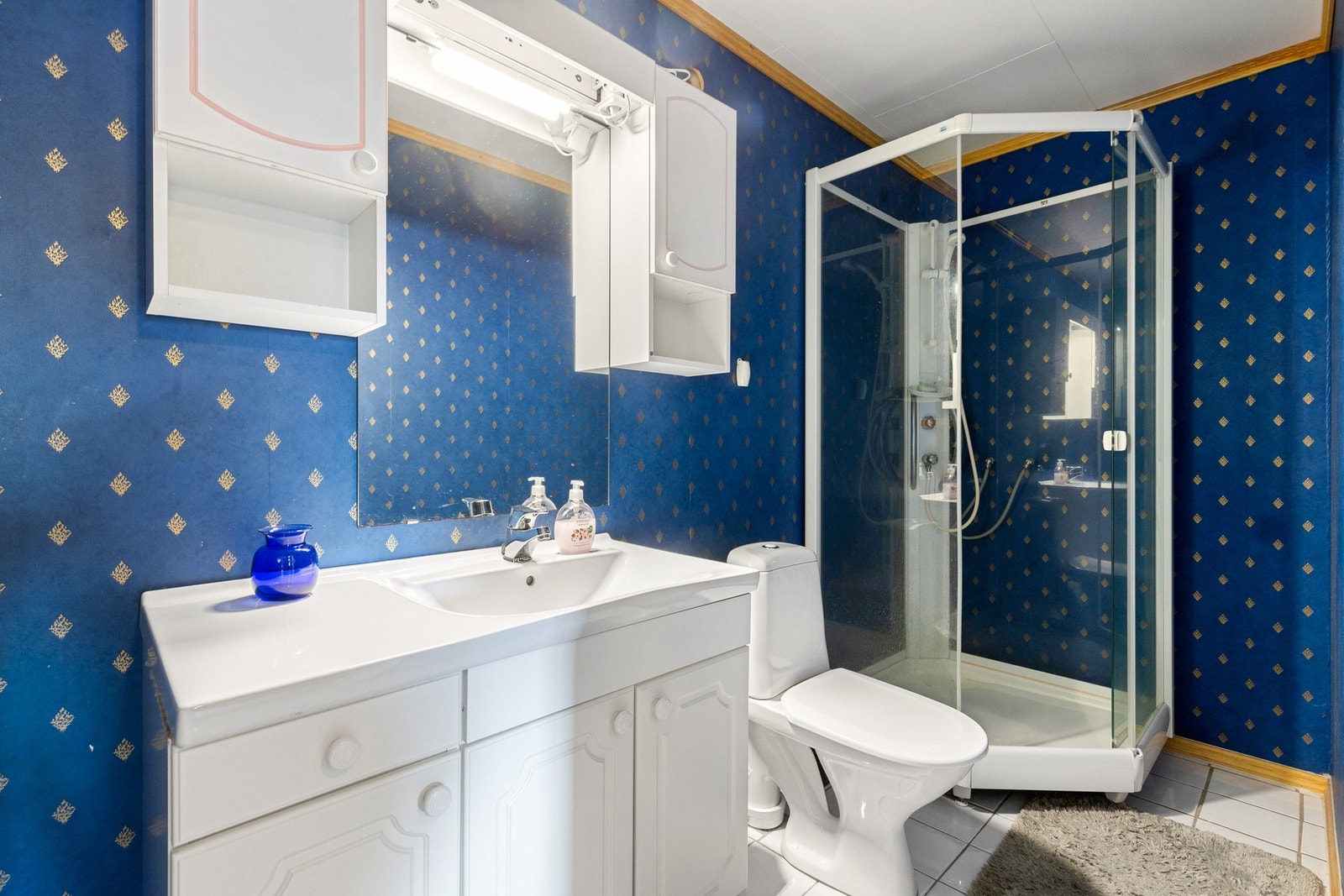 Baderommet er av god størrelse og er bestående av servant med underskap, dusjkabinett og toalett Galleribilde