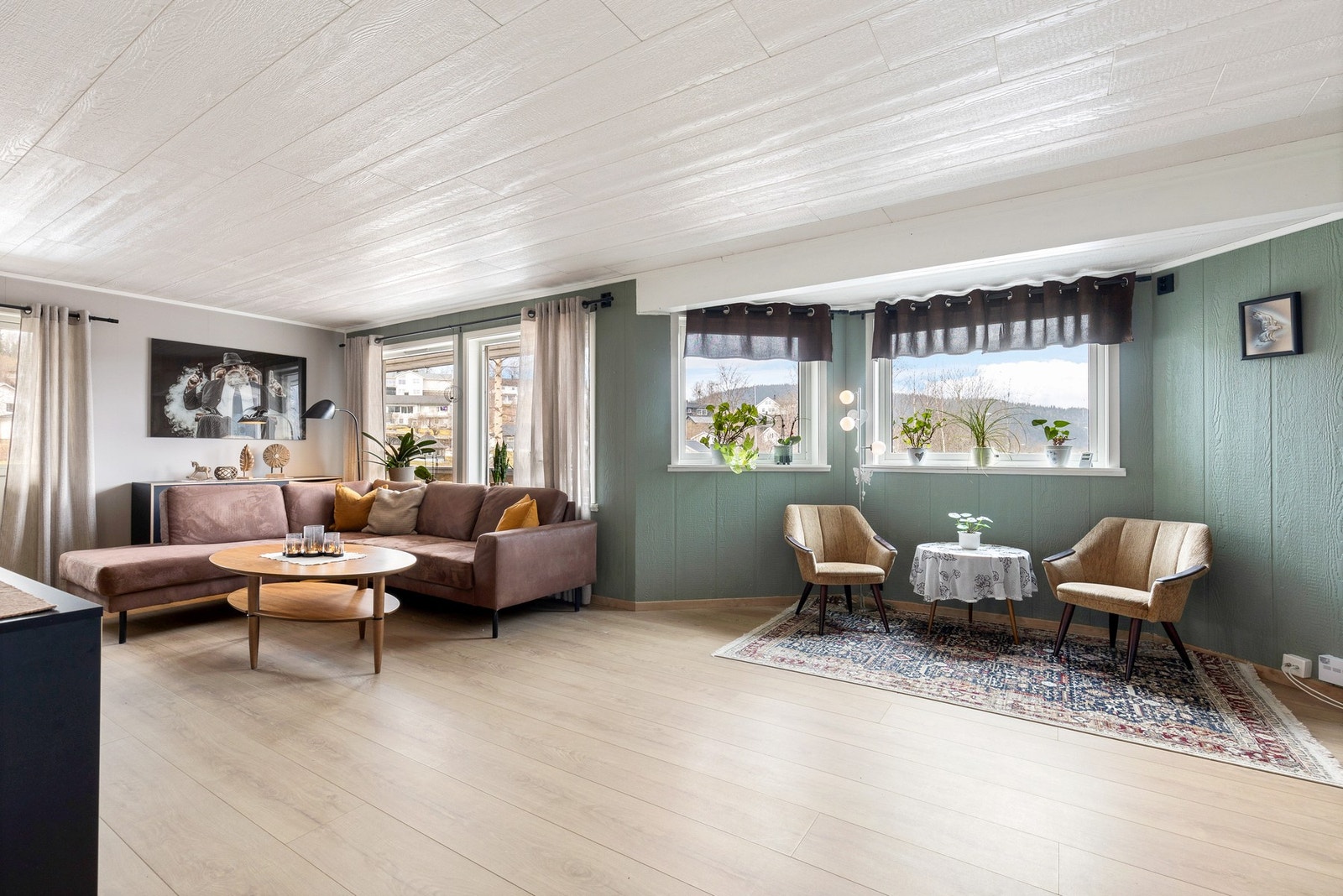 En lys og romslig stue som rommer god plass til flere sittegrupper Galleribilde