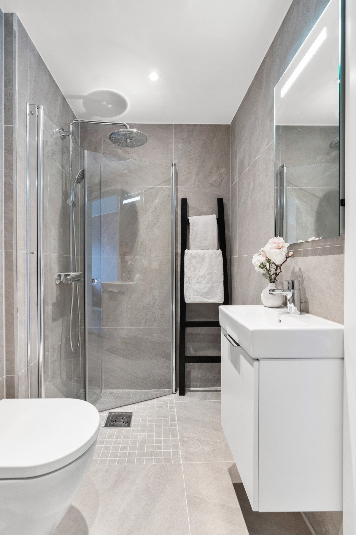 Innredningen består av et underskap, servant, speil med lys, stikk og en dusjsone med dusjing direkte på gulv og vegg. Galleribilde