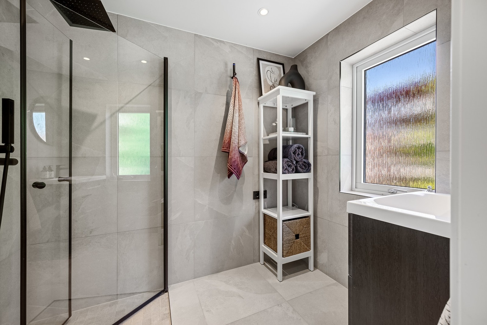 Badet er innredet med nedfelt servant, dusjhjørne med glassvegger og opplegg for vaskemaskin. Galleribilde