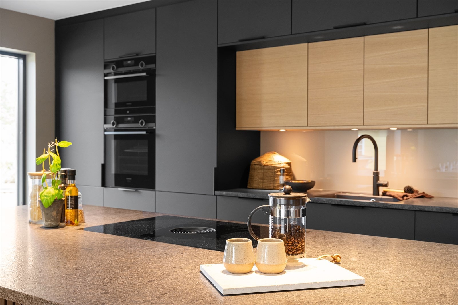 Nydelige fargekombinasjoner med benkeplaten av grantitt i fargen steel grey patneret som står i kontrast med resten av kjøkkenet som er i sort matt. Galleribilde