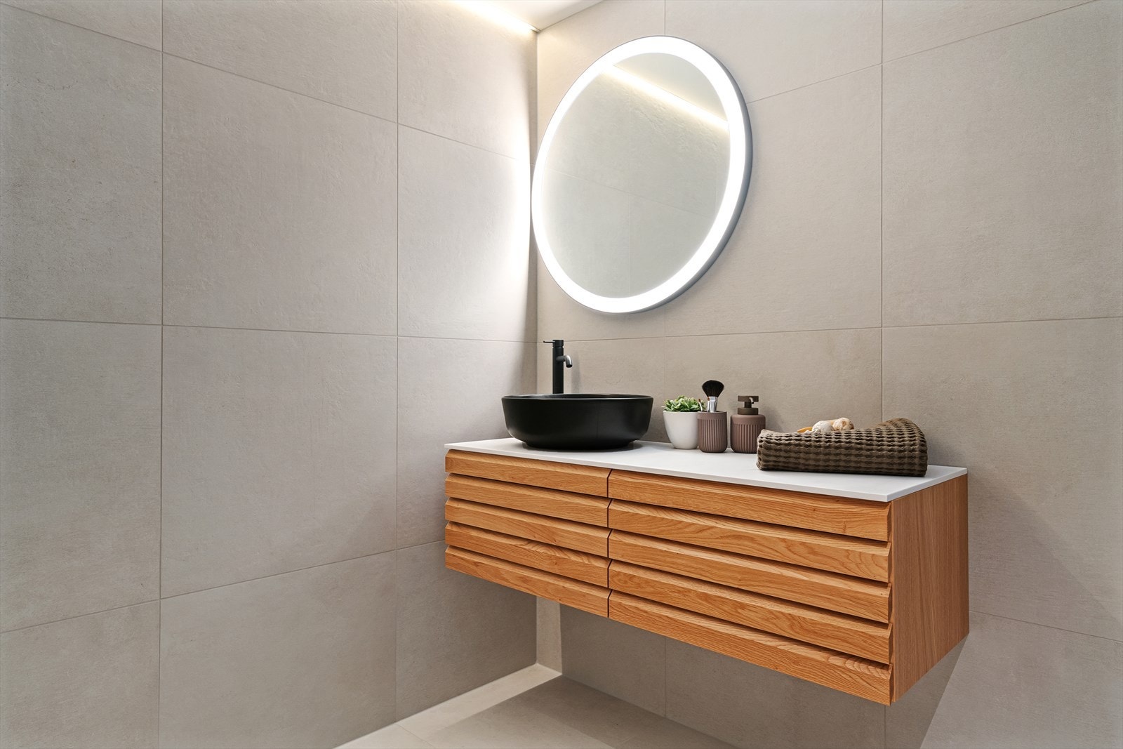 Badet inneholder servant med underskap, dusj med glassdører og vegghengt toalett. Galleribilde