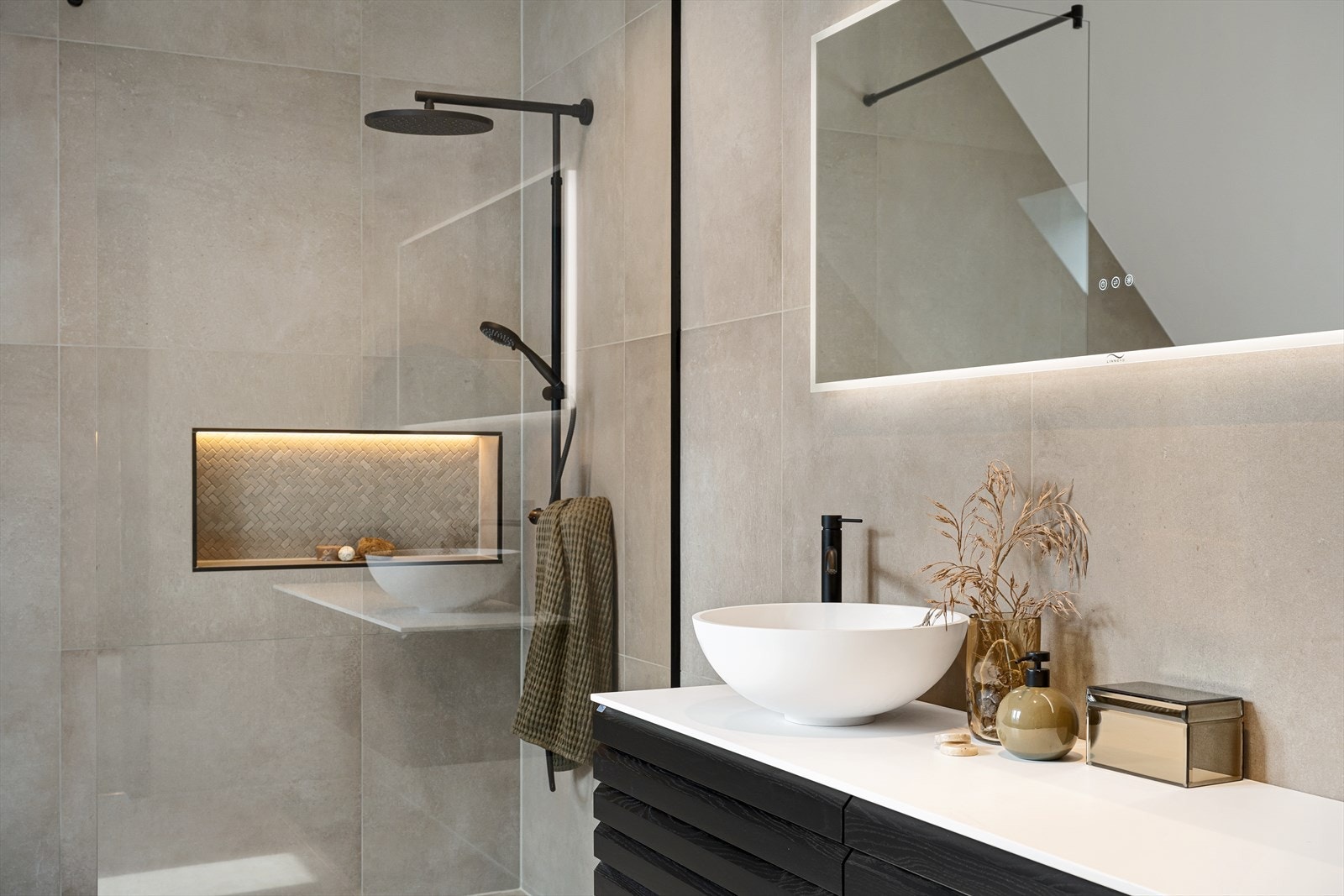 Rommet er innredet med servant med skuffeseksjon, overskap med speil, dusj med glassdører og vegghengt toalett. Galleribilde