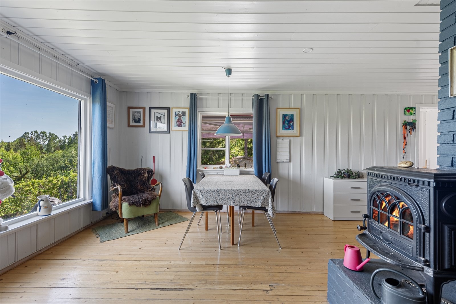 Stuen er L-formet og det er et naturlig skille mellom spisestue og stue ved vedovnen Galleribilde