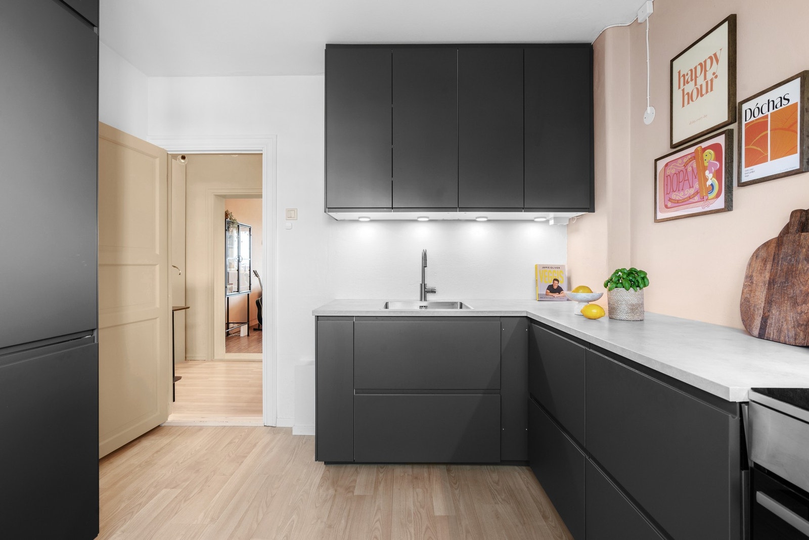 Innredningen har glatte fronter, laminat benkeplate med nedfelt oppvaskkum, og lys under overskap som gir funksjonelt arbeidslys Galleribilde