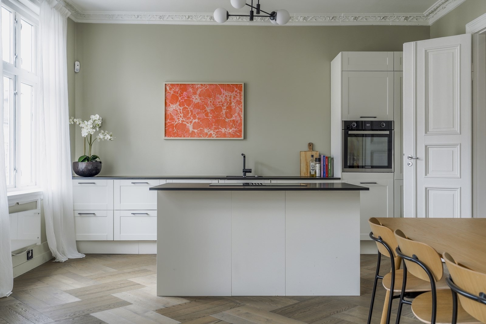 Kjøkkeninnredningen fra Epoc (2023) med hvite, profilerte fronter og laminert benkeplate. Kjøkkenet består av benkeskap, høyskap og en frittstående øy. Galleribilde