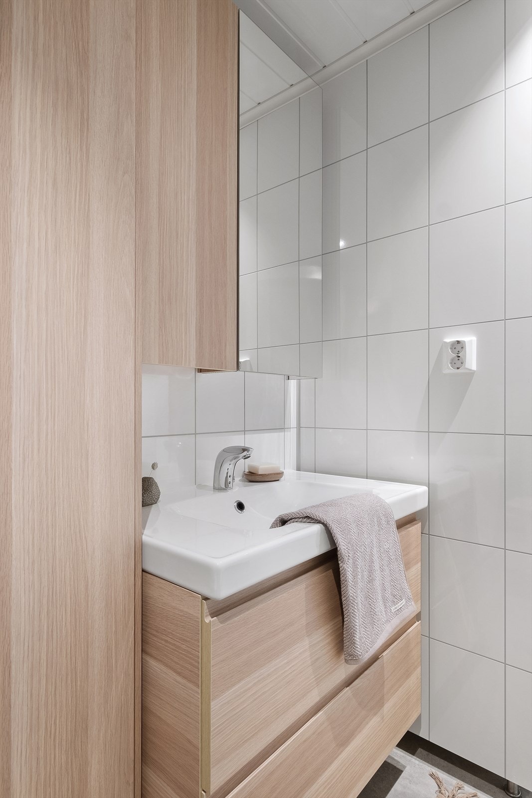 Badet er utstyrt med innredning med nedfelt servant, veggmontert toalett,
dusjkabinett, benkeinnredning med vaskekum bak skyvedører og opplegg for vaskemaskin. Galleribilde