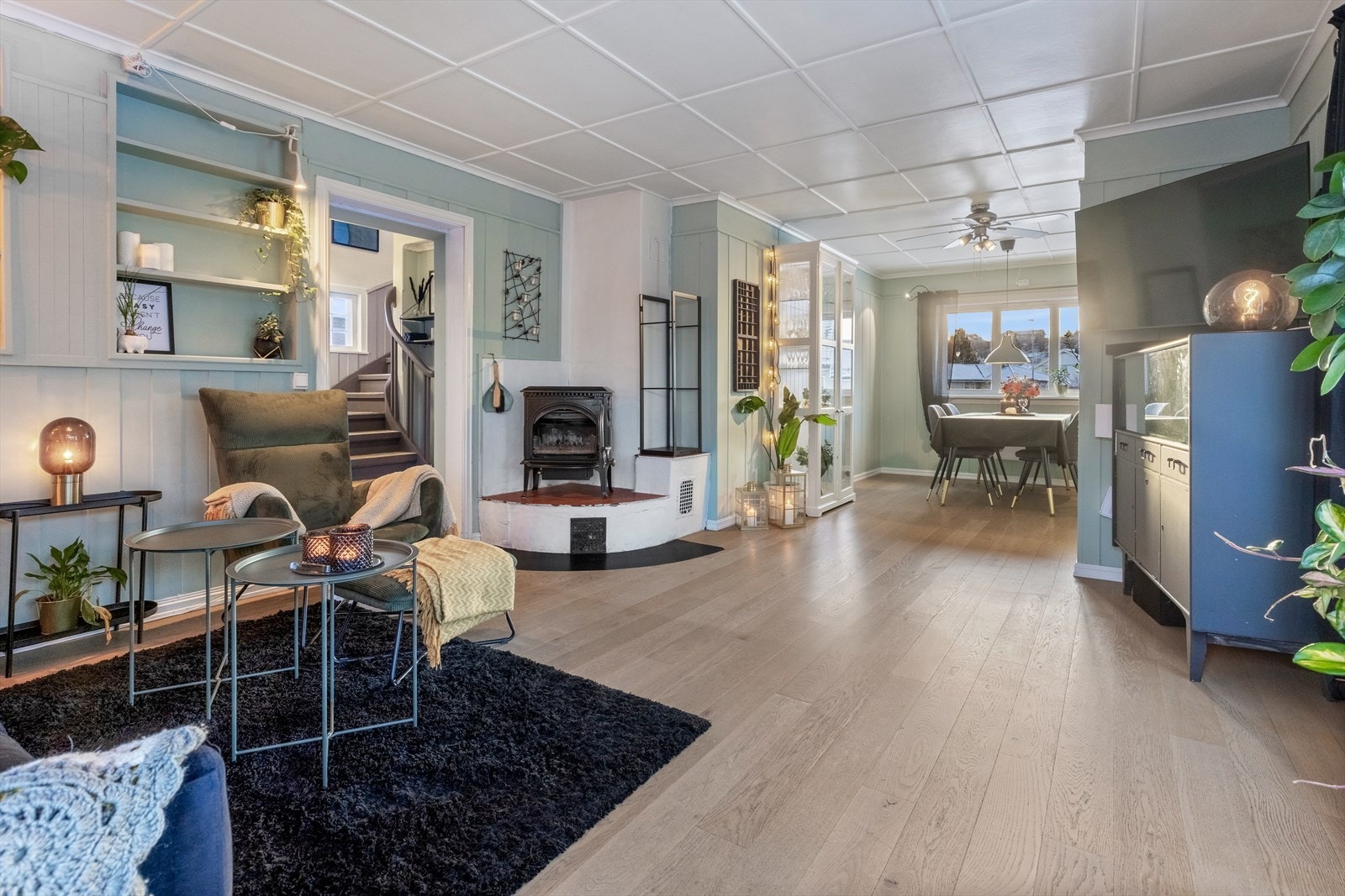 I stuen er det montert en lukket peisovn ved pipeløp som også har varmluftskanal fra vedovn i kjeller. Galleribilde