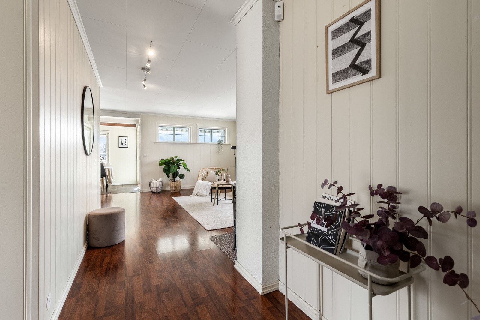 Vel inne er det en fin entré med lysmalt panel på veggene og gyllen, trestavs laminat på gulvet. Galleribilde