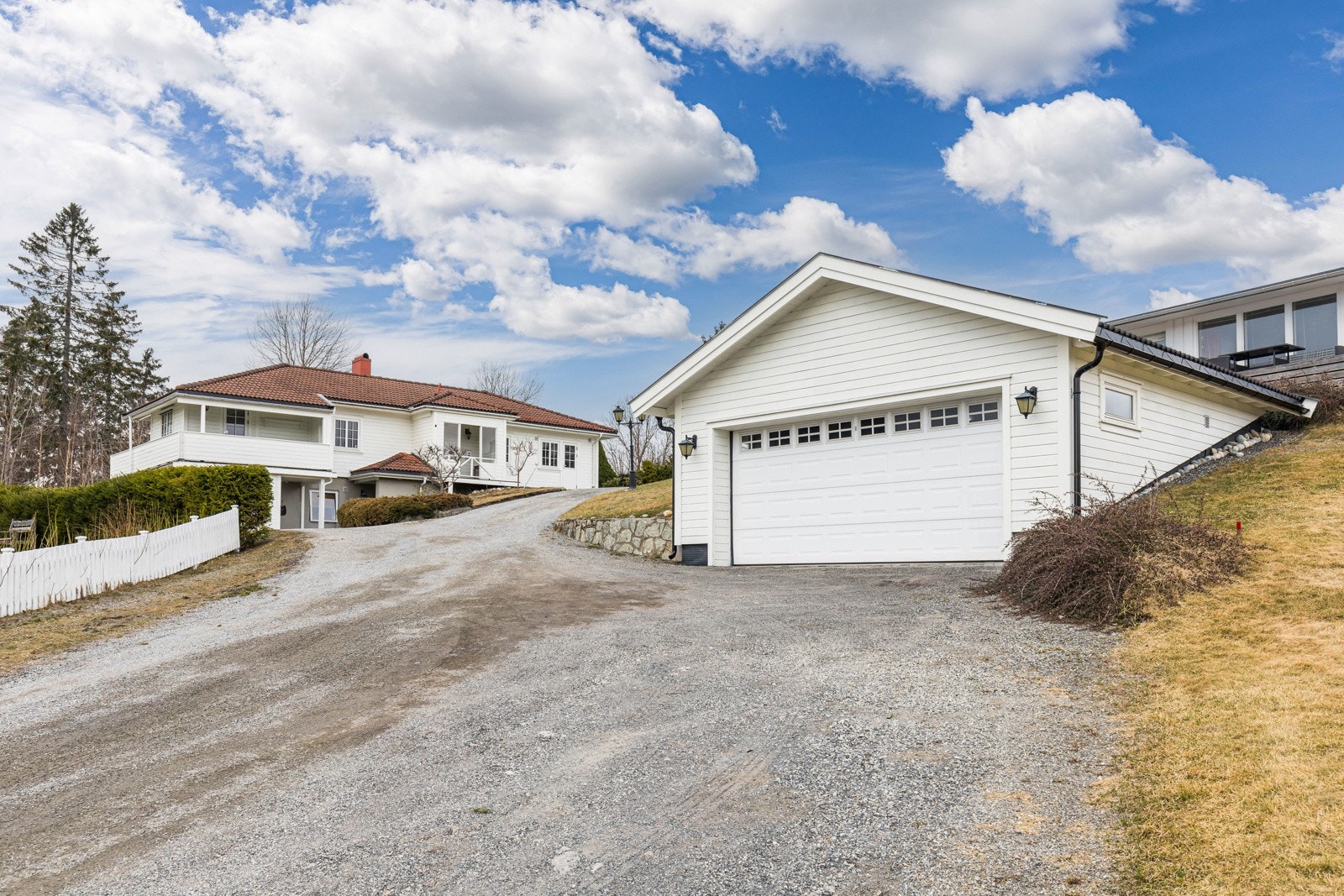 Det er parkering i en frittliggende dobbelgarasje og på en gruslagt gårdsplass. Galleribilde