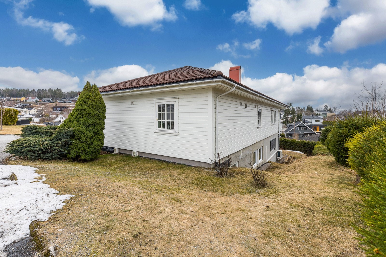 Tomten er pent opparbeidet med gressplen, vintergrønne prydbusker og gruslagt gårdsplass, og det er mye boltreplass i en skjermet hage. Galleribilde