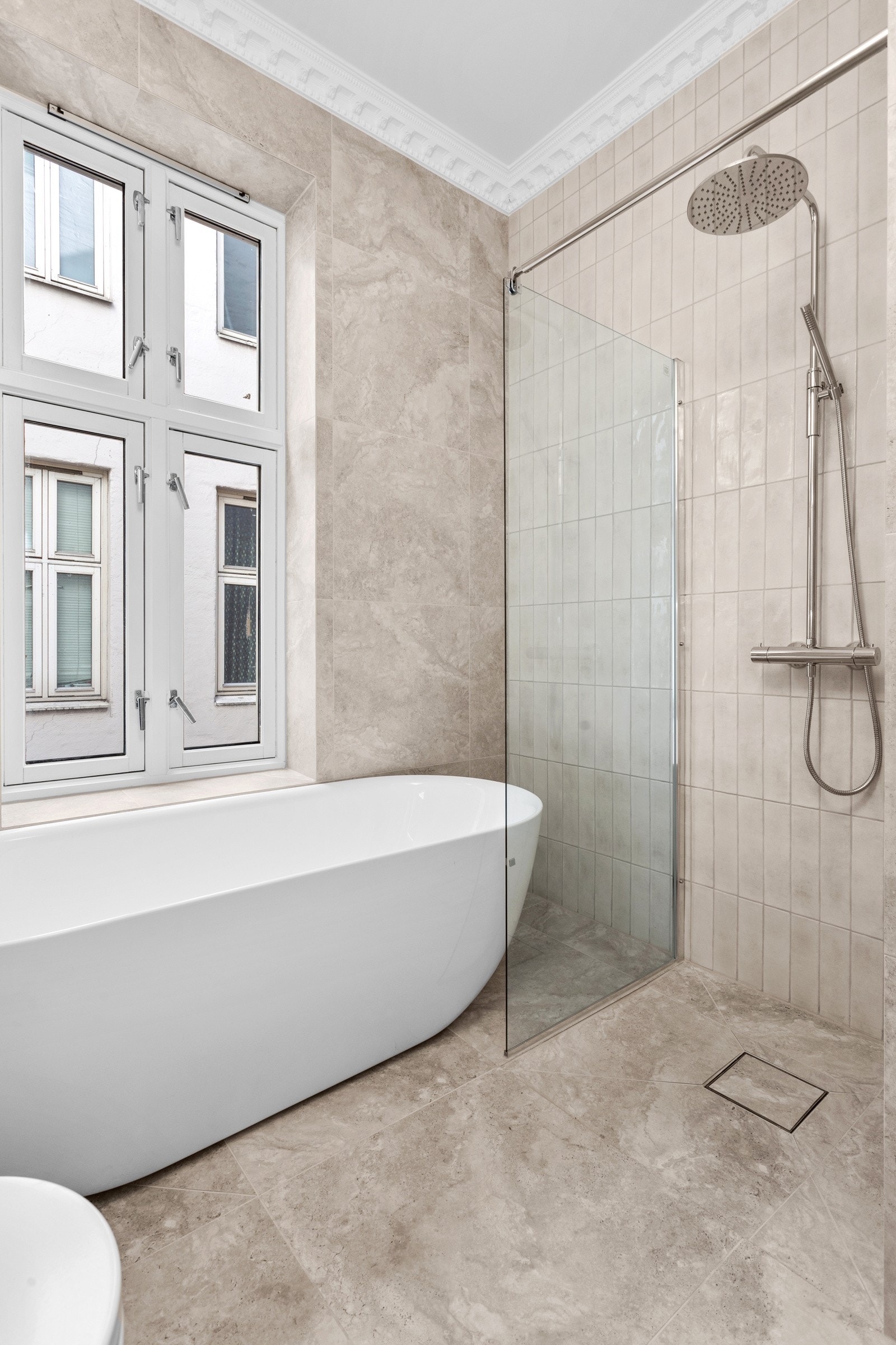 Klassisk eleganse på baderom med full takhøyde, stukkatur og rosett. Galleribilde