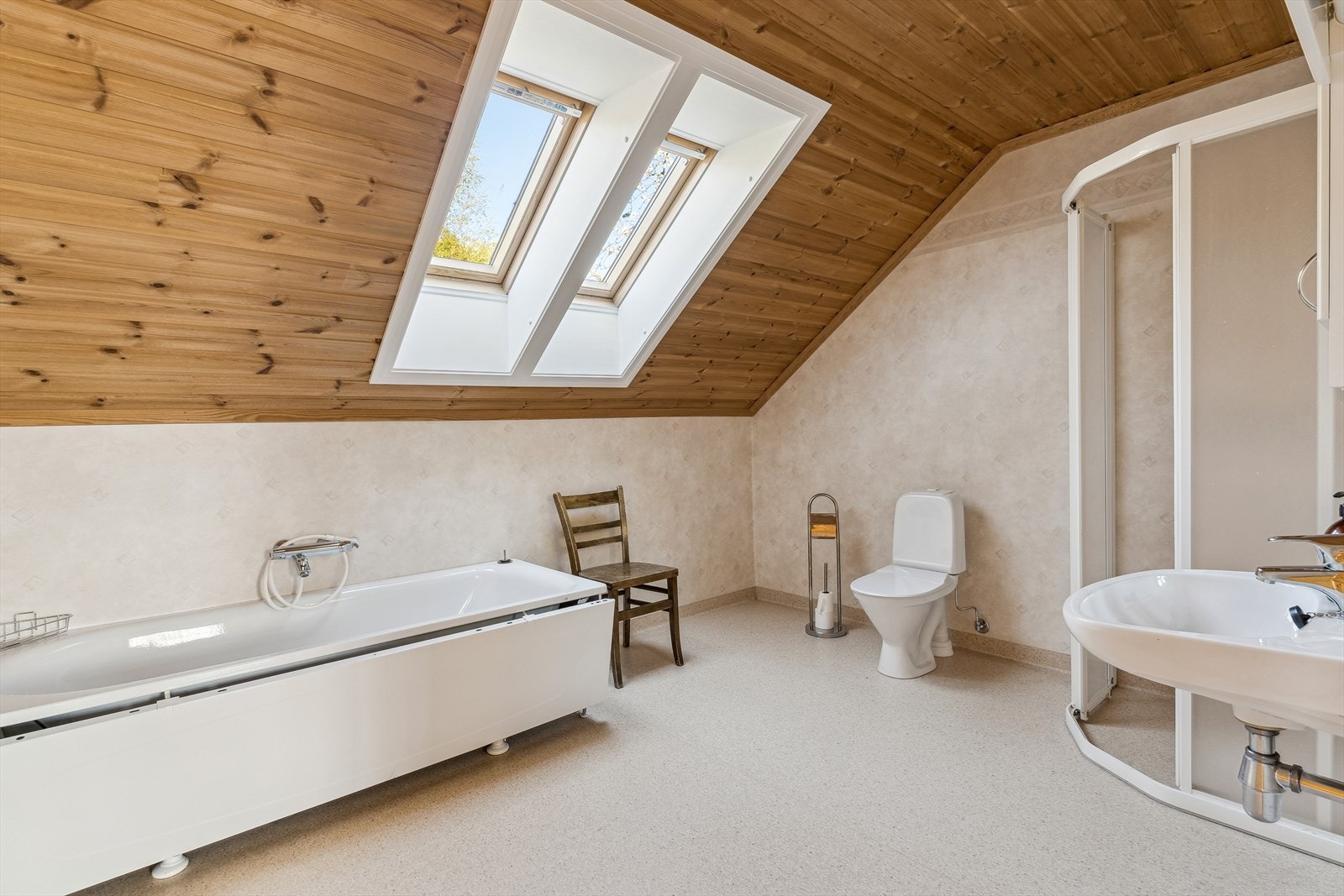 Badet i loftetasjen er innreda med badekar og dusj, samt toalett og enkel innreiing med vegghengt servant og skap. Galleribilde