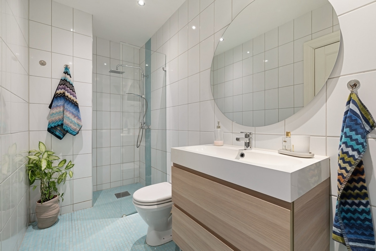 Delikat, flislagt baderom med varme i gulv og downlights i himling Galleribilde