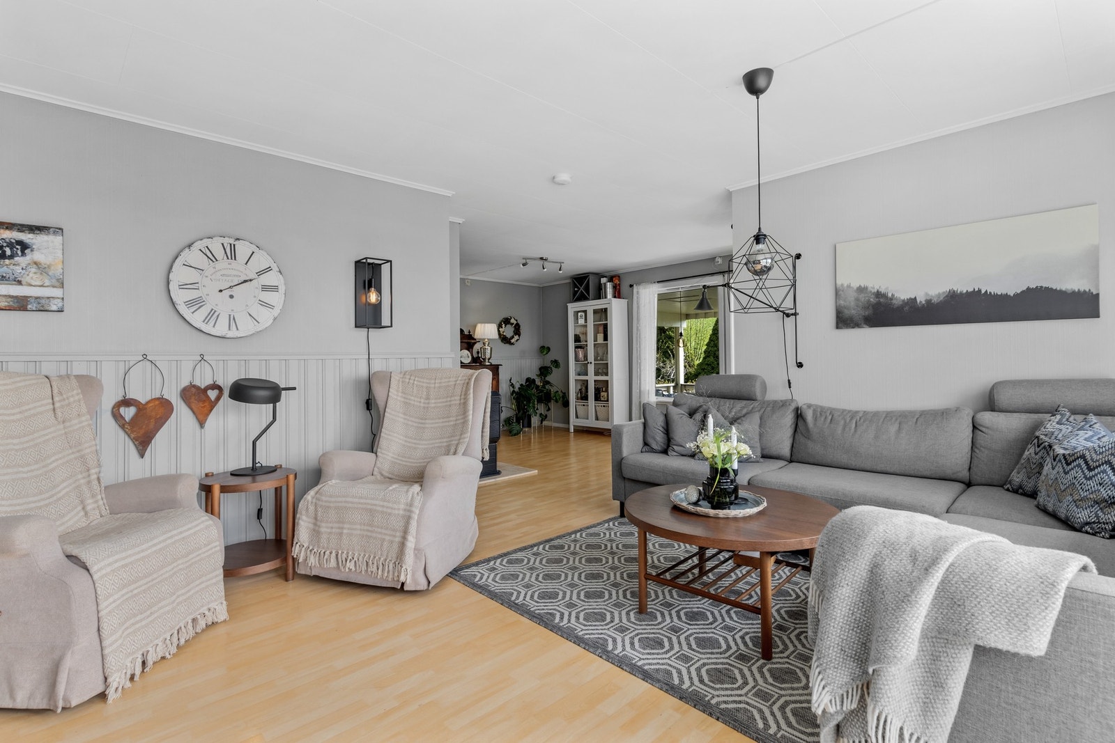 Stor stue med to soner. Utgang til en stor takoverbygd terrasse på enden av huset. Galleribilde