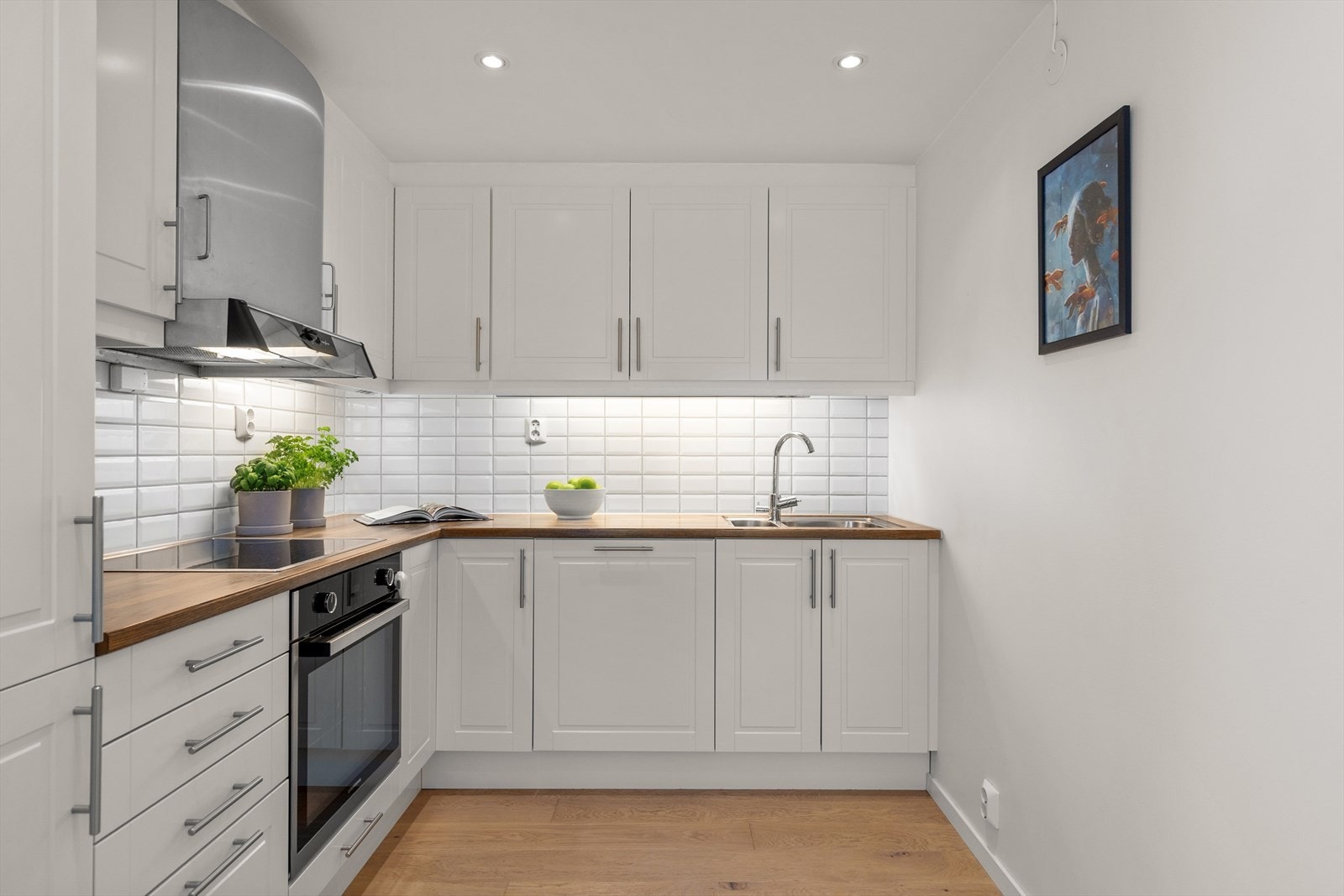 Fliser er montert på vegg over benk. Integrert komfyr (2022) med induksjons platetopp, oppvaskmaskin og kjøl/frys. Stoppekraner er montert på vanninntak i benkeskap. Komfyrvakt er montert. Galleribilde