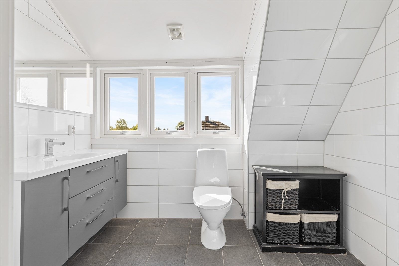 Badet innehar toalett, servant med skuffer og skap, samt dusjnisje med innfellbare glassdører. Galleribilde