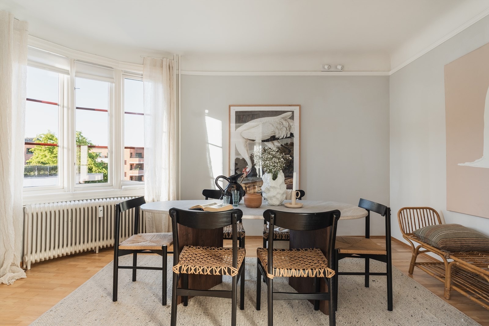 Spisestue og stue danner hver sin sone, og store vindusflater slipper inn rikelig med dagslys, noe som gjør at leiligheten føles lys og luftig. Galleribilde