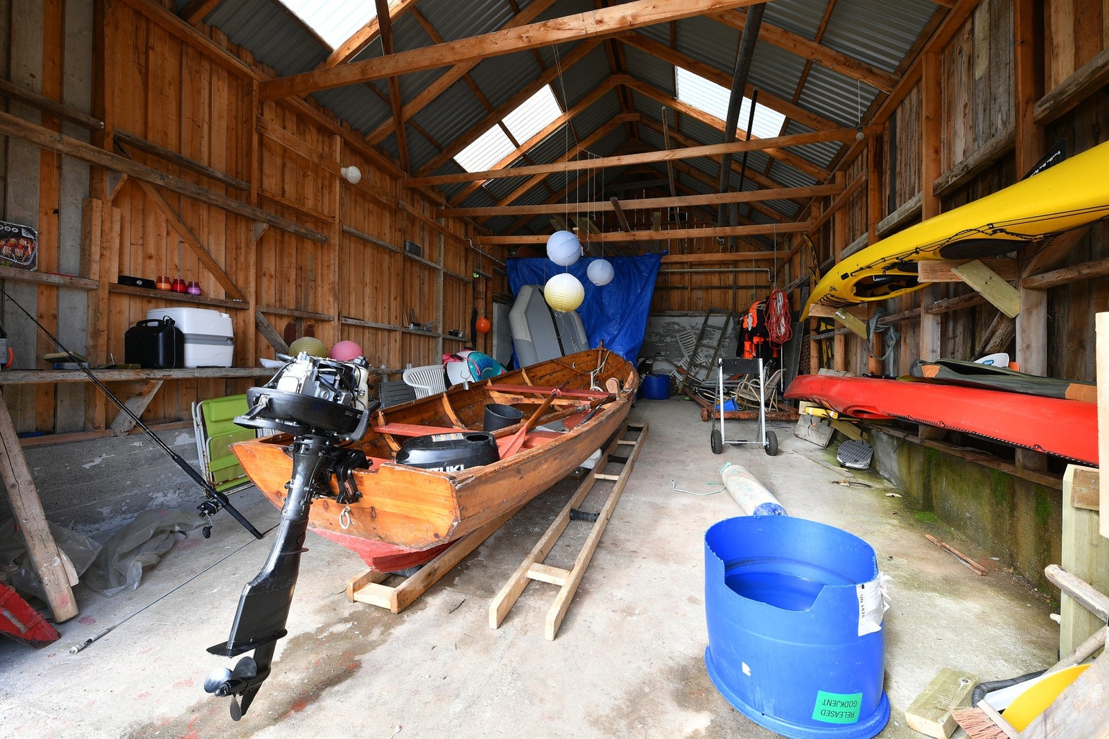 Romslig naust med god plass til båt og henge opp kajakker på veggen. Galleribilde