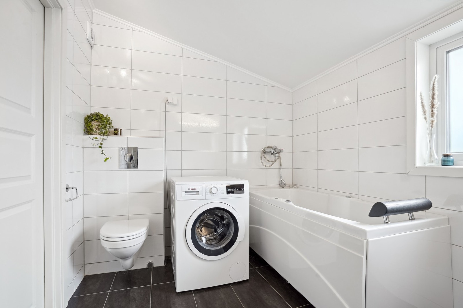 Innredet med vegghengt toalett, opplegg for vaskemaskin, badekar - Galleribilde