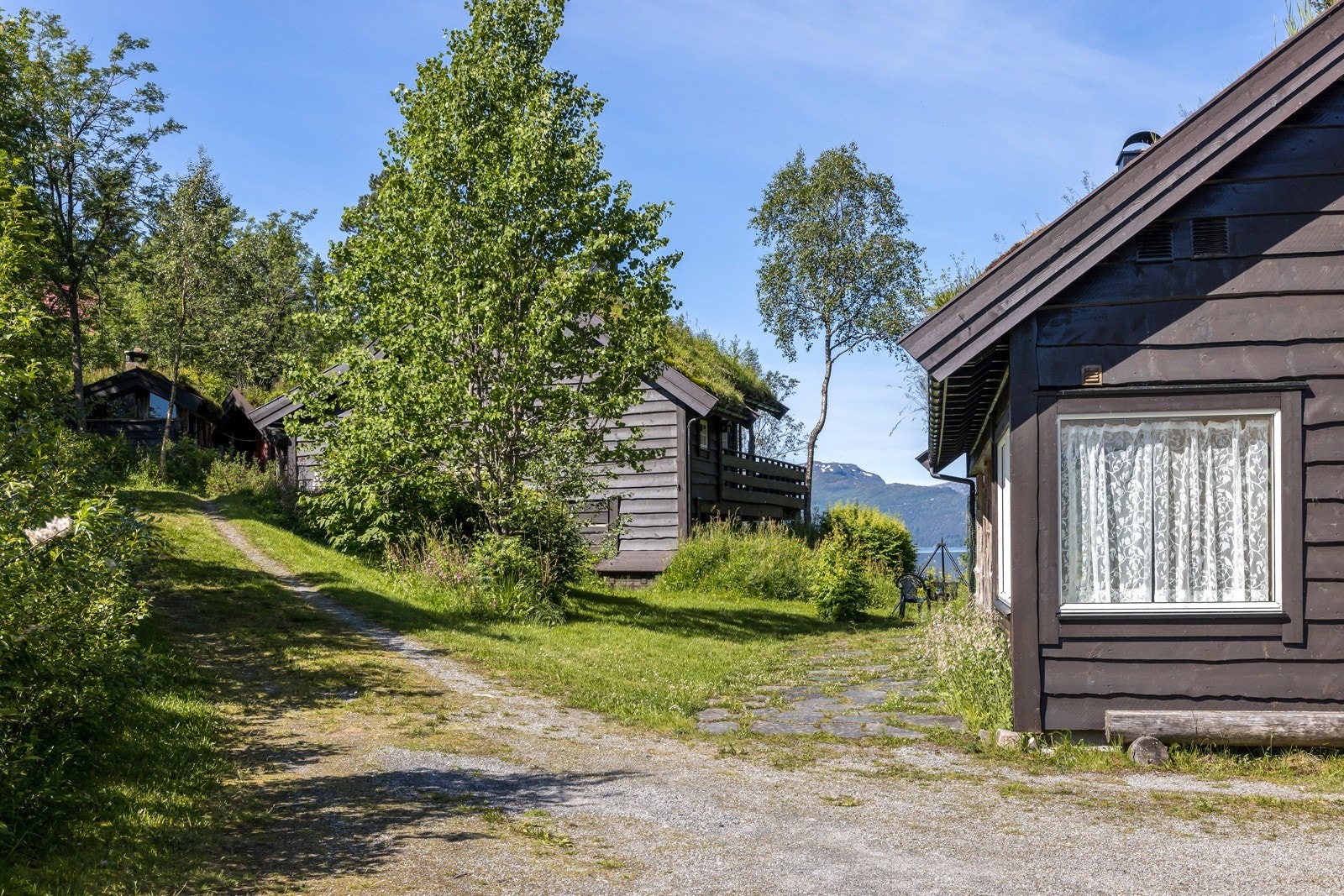 Her ser ein nyestova til høgre og gamlestova samt eldhuset til venstre Galleribilde