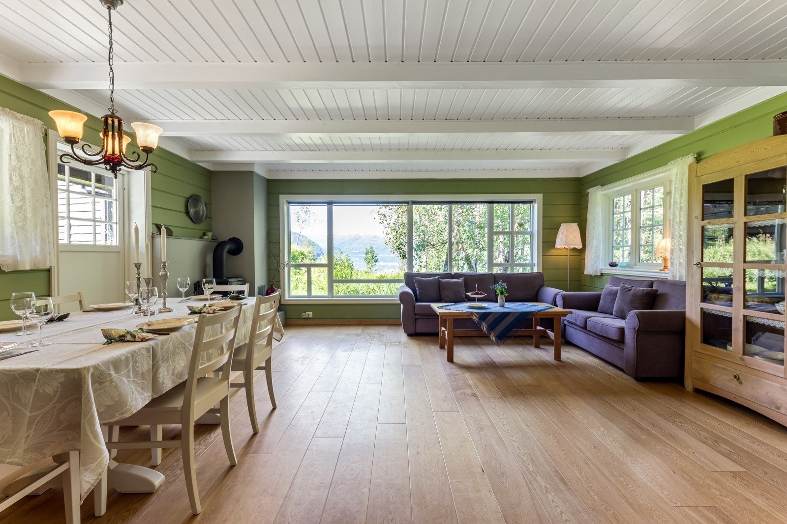 Stova i nyestova er romsleg og luftig med opa kjøkkenløysing, tilkomst til uteområde og store vindaugsflater mot vest Galleribilde