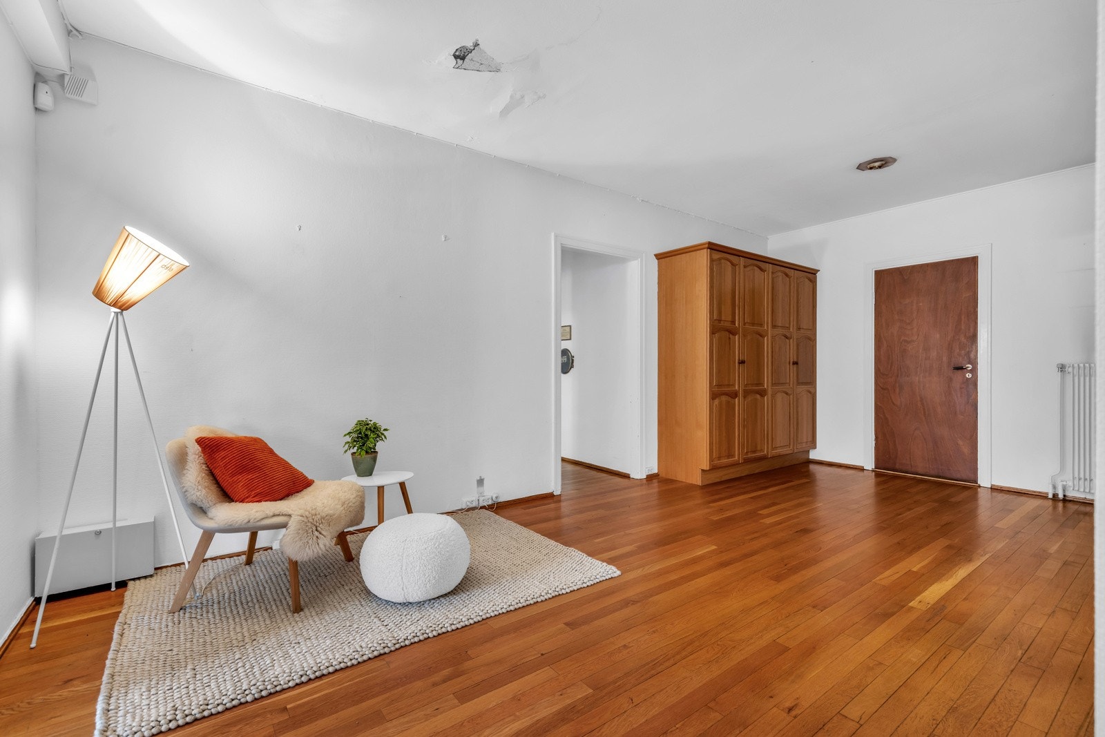 Hallen har parkett på gulv og inngang til gjeste-bad. Galleribilde