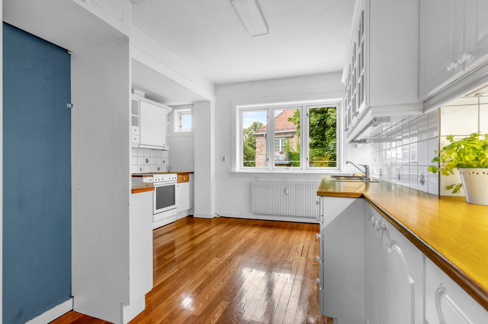 Benke- og overskap med slette fronter, benkeplate av laminat og fliser på vegg over benk. Frittstående komfyr, kjøleskap og oppvaskmaskin. Oppvaskkum av stål. Ventilator med kullfilter. Galleribilde