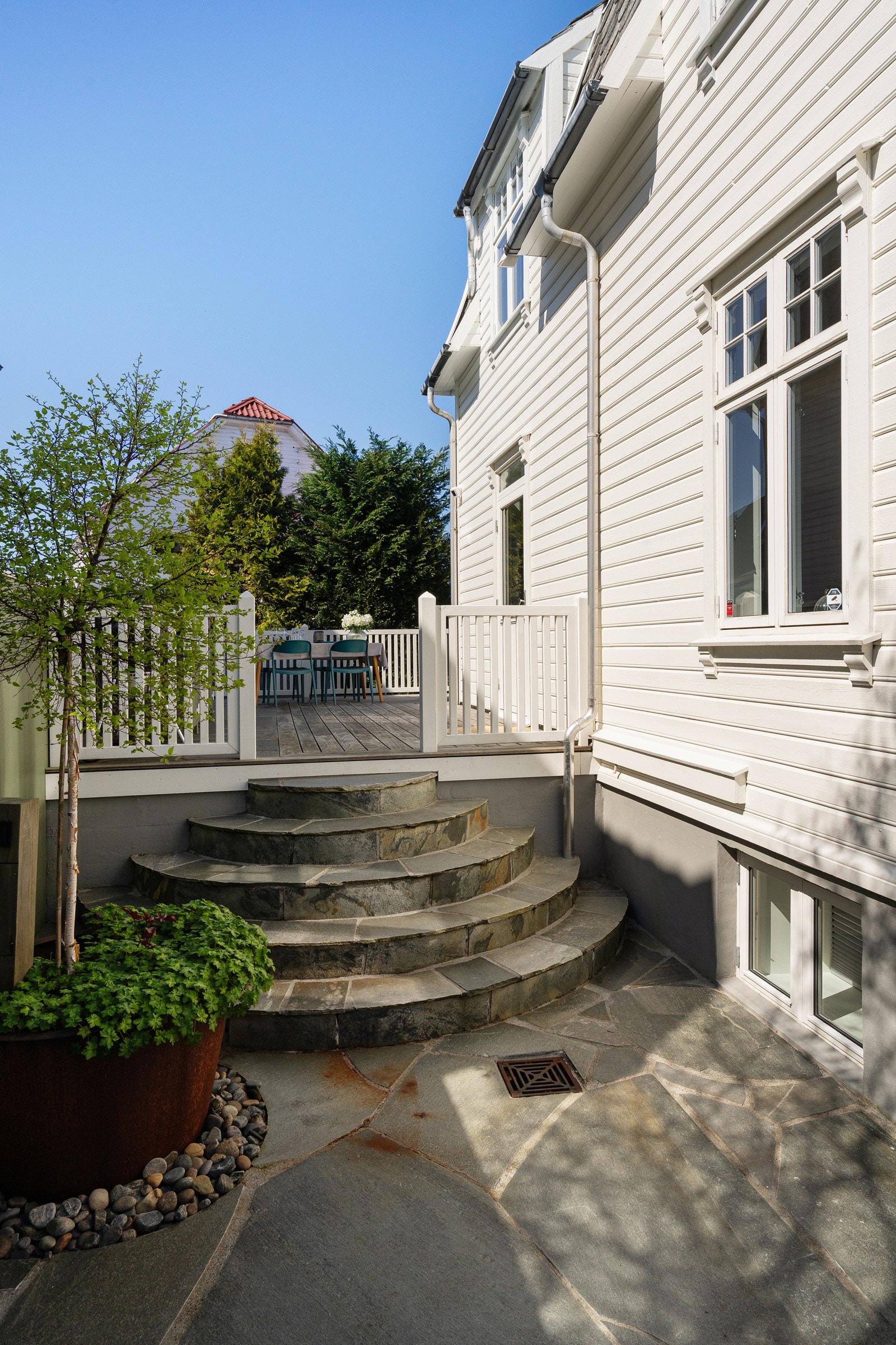 Uteområdet er preget av materialvalg av høy kvalitet som lekkre skifter heller og stor blomsterpotte i kortenstål. Galleribilde