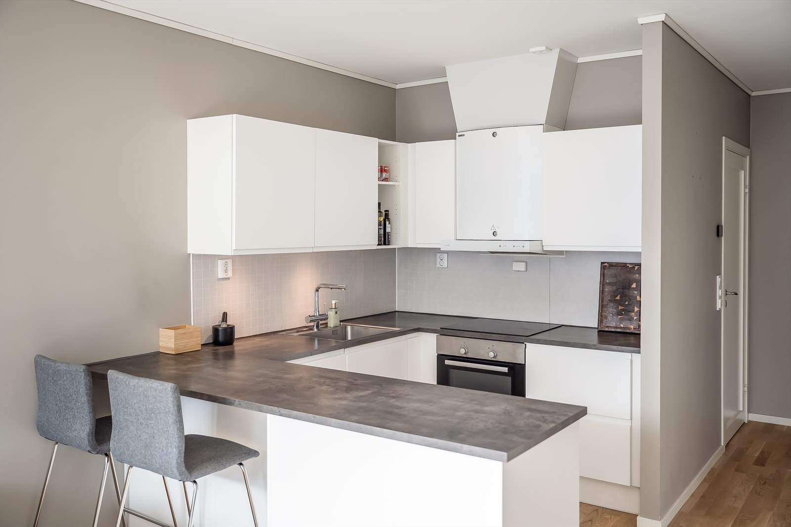 Her får du et lyst og moderne hjørnekjøkken fra byggeår i stilrent design. Galleribilde