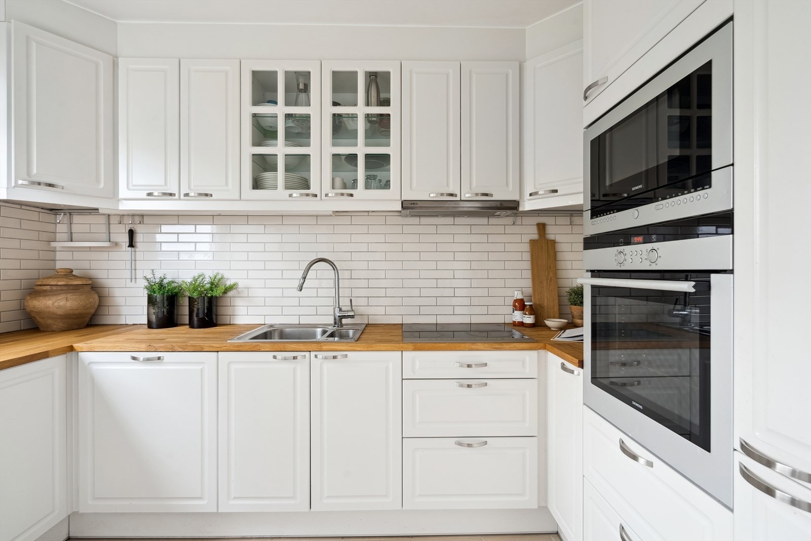 Kjøkkeninnredningern består av profilerte fronter og en stor benkeplate av tre, samt mye skapplass til oppbevaring. Galleribilde