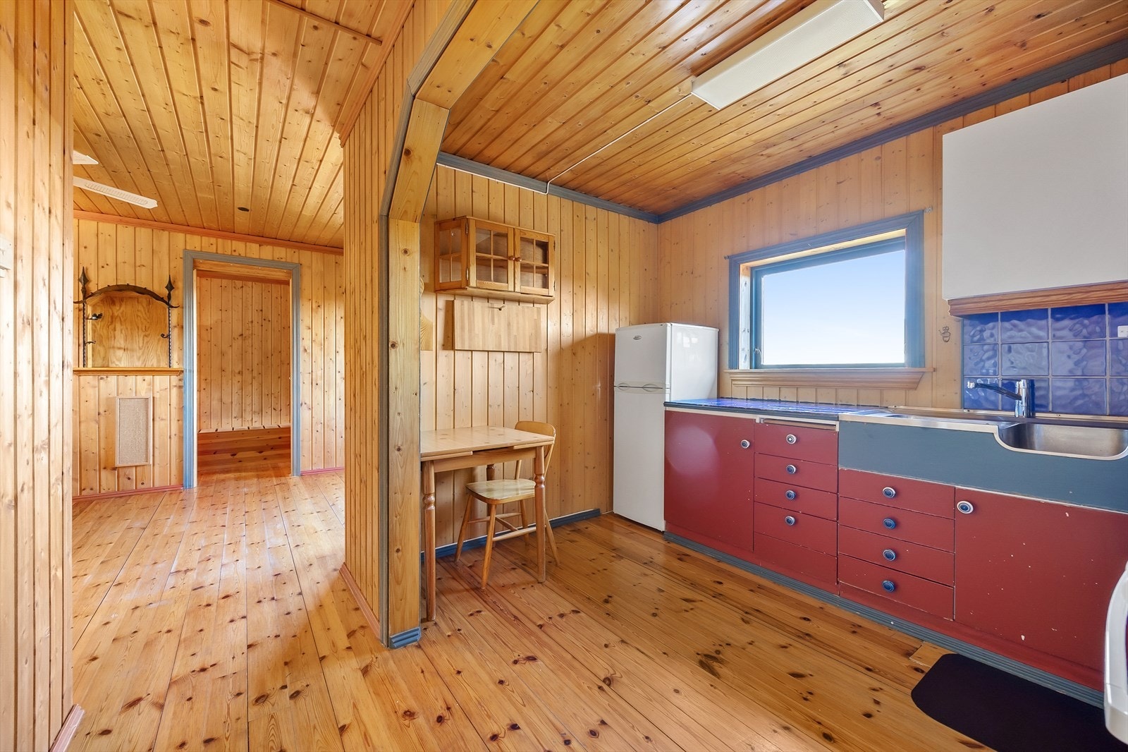 Kjøkken i fritidsbolig med rød innredning. Galleribilde