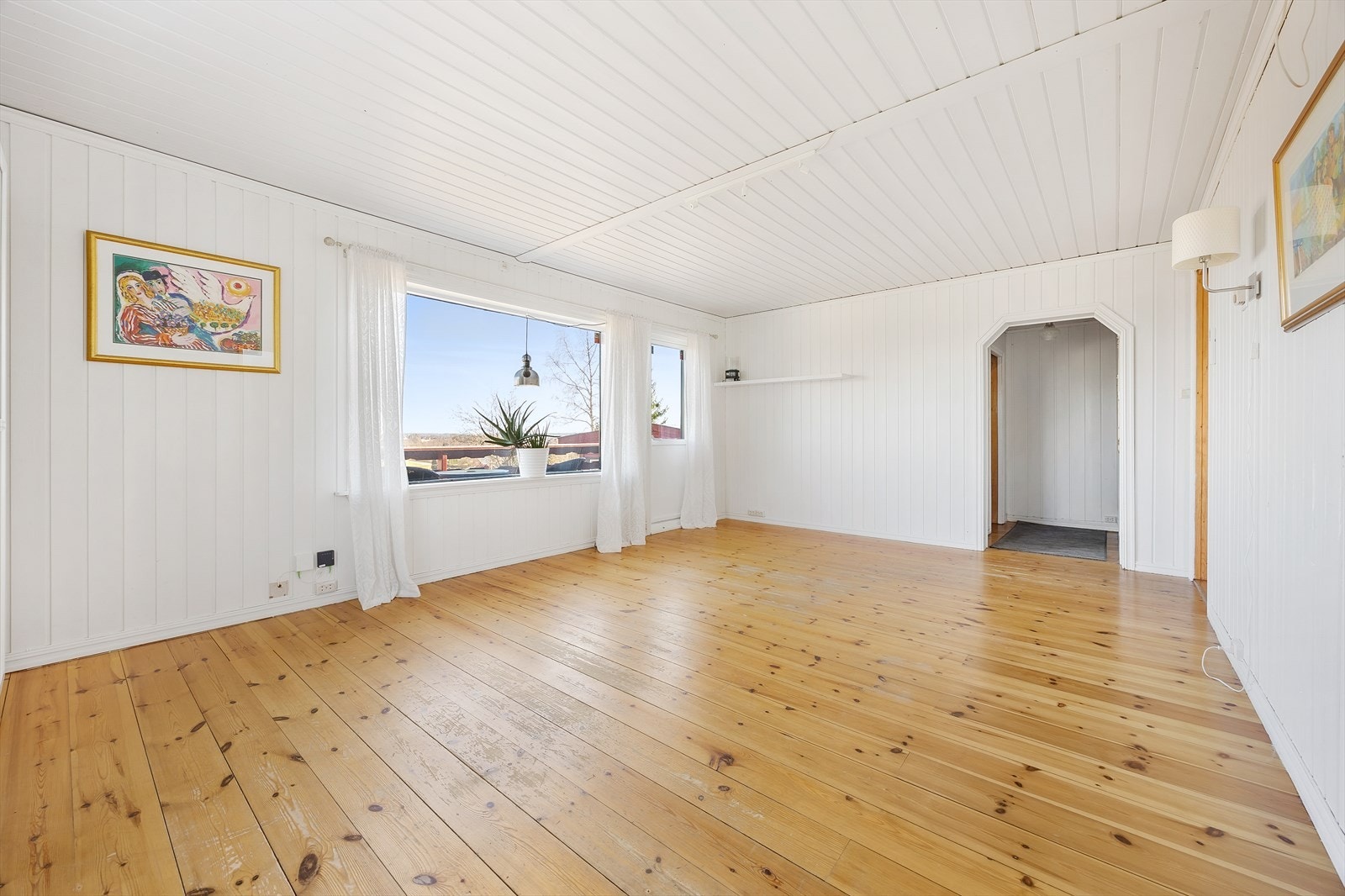 Lys og romslig stue med panelvegger. Galleribilde