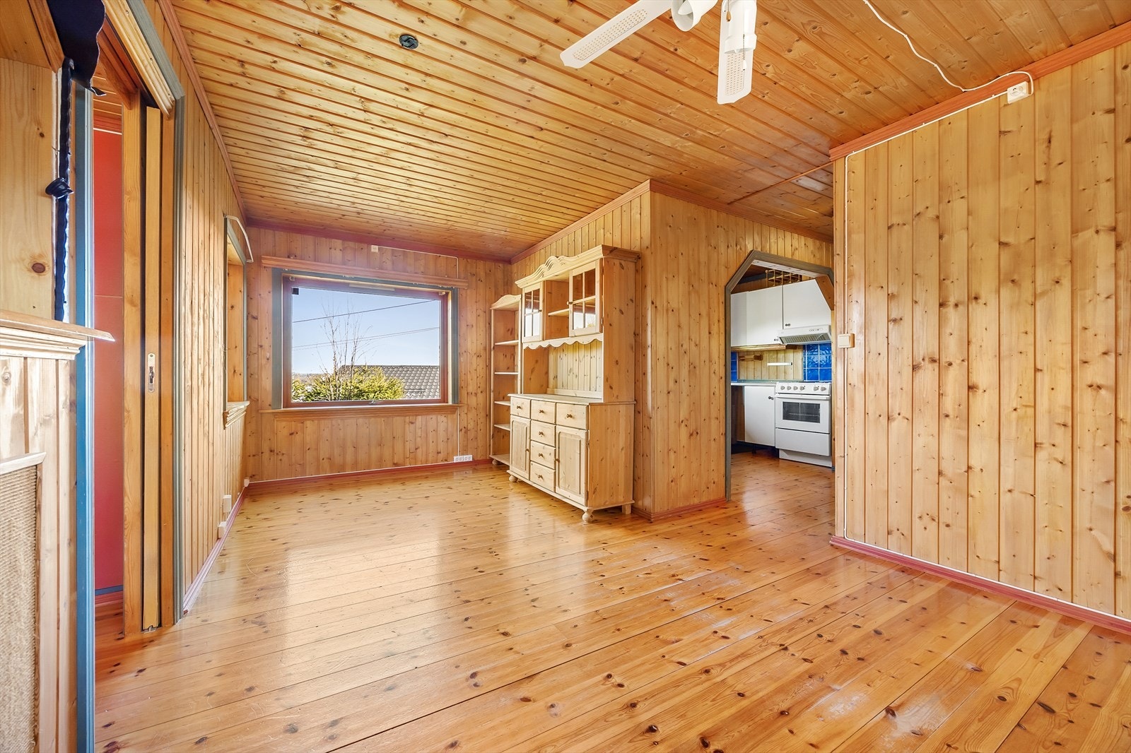 Lys stue med trepanel og store vinduer. Galleribilde